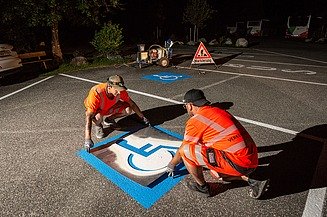 Foto von Bauarbeitern die eine Parkplatzmarkierung anbringen